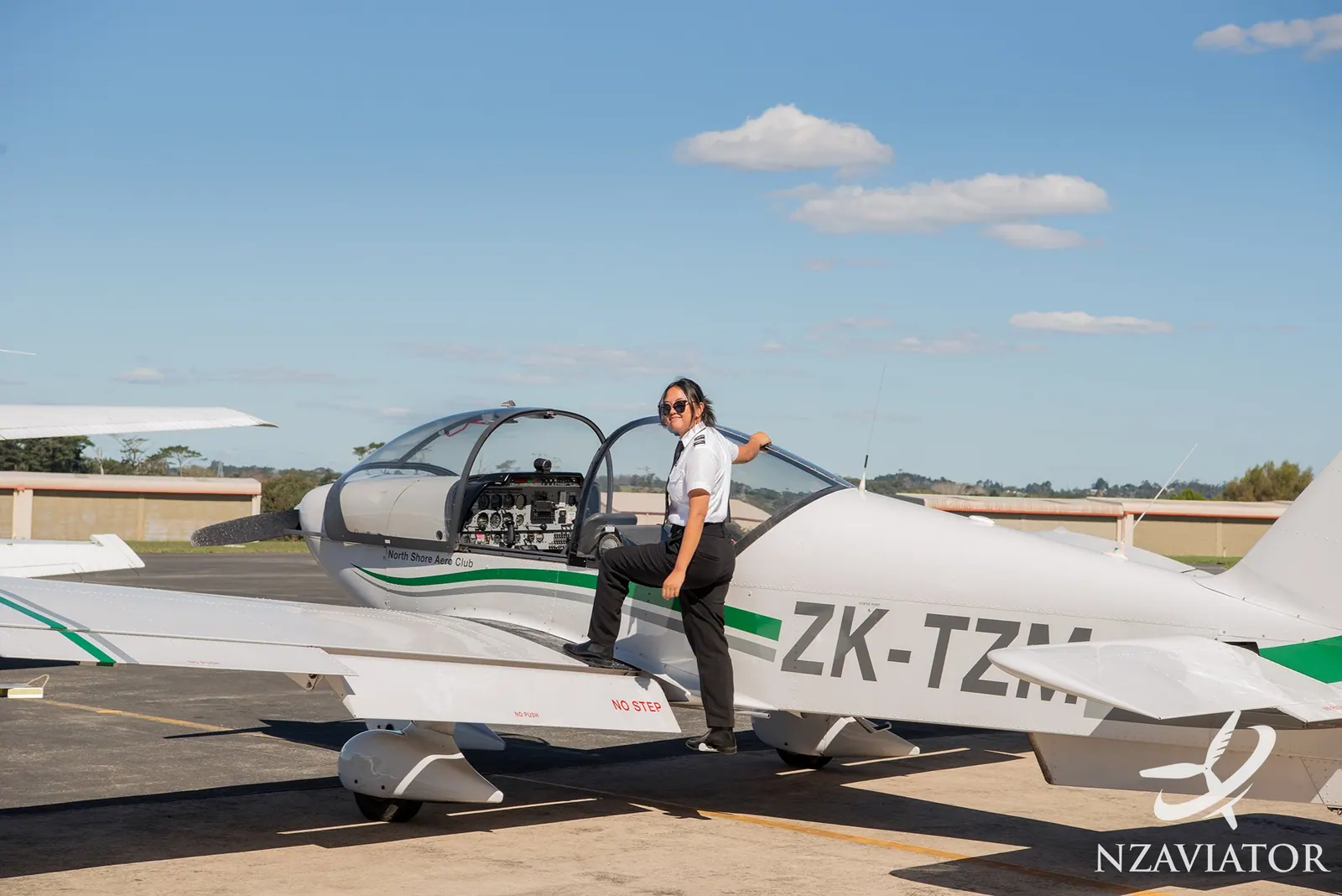 A student pilot climbing onto the wing of a training aircraft